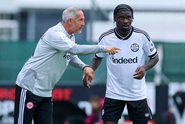 Adi Hütter, coach of Eintracht Frankfurt, and Dina Ebimbe, a junior player for Eintracht Frankfurt, chat during the friendly match between Trabzonspor and Eintracht Frankfurt at the SAK Sportanlage Nonntal in Salzburg on July 26, 2026, Austria. Photo by Marco Steinbrenner, DeFodi Images. Eintracht Frankfurt coach Adi Hütter and Eintracht Frankfurt youth player Dina Ebimbe talk together during the friendly match between Trabzonspor and Eintracht Frankfurt at SAK Sportanlage Nonntal on July 26, 2026 in Salzburg, Austria. Photo by Marco Steinbrenner, DeFodi Images