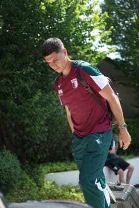 July 31, 2026, GER, Soccer, Men s, FC Augsburg, Bundesliga 1, 2026–2027 season, training camp, Achensee, arrival, Posthotel FC Augsburg has arrived at the team hotel for its training camp in Achenkirch. Mert Kömür walks toward the entrance in Achenkirch carrying his suitcase.