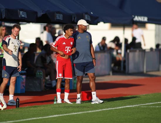 Soccer, Men s, Bundesliga, 2026–2027 Season, FC Rottach Egern vs. FC Bayern Munich, Friendly Match, Training Camp, Rottach Egern: Nathaniel Brown (FC Bayern Munich, left) with Vincent Kompany (FC Bayern Munich coach, right), standing on the sideline before his substitution