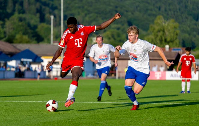 July 30, 2026, 2026–2027 Bundesliga, FC Bayern Munich training camp in Rottach Egern on Lake Tegernsee, Bavaria; friendly match between FC Rottach Egern and FC Bayern Munich; Bastian Assomo (left); FC Bayern Munich in a tackle