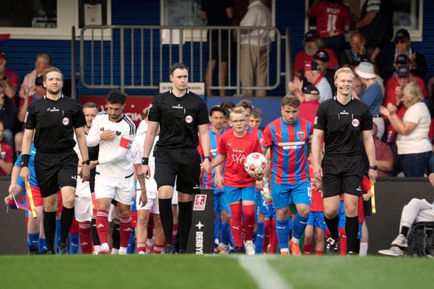 Photo: The trio of referees and the two teams head toward the center circle. Regional League North soccer, Matchday 1 on Friday, July 31, 2026: SV Drochtersen vs. Phönix Lübeck