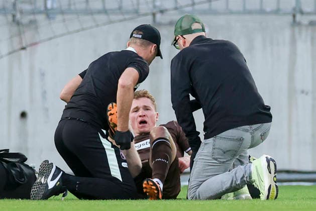 Rawley St John of FC St Pauli is lying injured on the field and receiving treatment during the preseason friendly match between FC St Pauli and RC Deportivo La Coruna at Millerntor Stadium on August 1, 2026, in Hamburg, Germany. Photo by Marco Steinbrenner, DeFodi Images