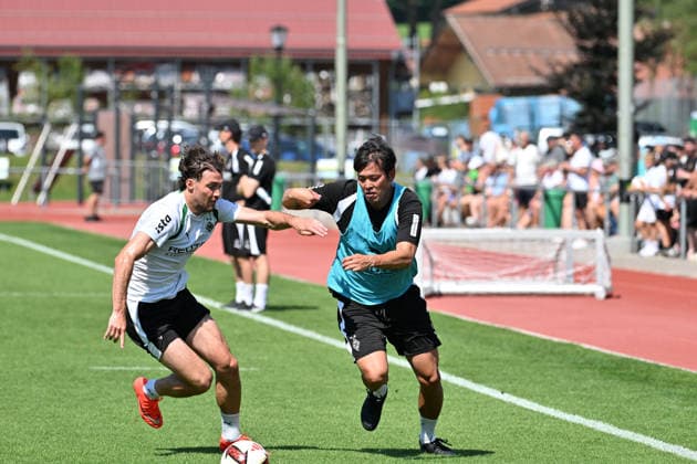 August 4, 2026 Rottach Egern Soccer, Men s, 2026–2027 Season, Borussia Mönchengladbach Training Camp: At Gladbach, even the interpreter joins in during training. Pictured here: Interpreter Atsushi Waki (right) in a tackle with Joe Scally (Gladbach, left). DFL regulations prohibit any use of photographs as image sequences and or quasi-video. Am Birkenmoos Stadium, Bavaria, Germany