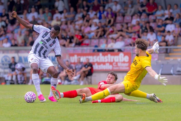 Memmingen, Germany, August 3, 2026, Toto Cup, Bavarian State Cup 2026–2027, Round 2, FC Memmingen vs. FC Ingolstadt 04. Pictured from left: Obed Ugondu (FCI) and goalkeeper Dominik Dewein (FCM) in a tackle at ArenaPark Bavaria Copyright: xFotostandx xSchäferx