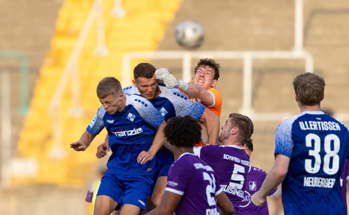 Elias Rogg, goalkeeper for TSV Schwaben Augsburg, makes a fist save in front of Elidon Qenaj of FVI TSV Schwaben Augsburg vs. FV Illertissen, Toto Cup