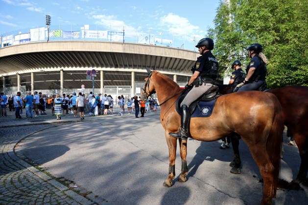 Soccer, Men s, Bavarian Regional League, 2026–2027 Season, TSV 1860 Munich vs. FC Augsburg II, Grünwalder Stadium: Here, a mounted police unit, police horses, police, security match, high-security match, danger, fans, security—with the Westkurve of the Grünwalder Stadium in Munich in the background