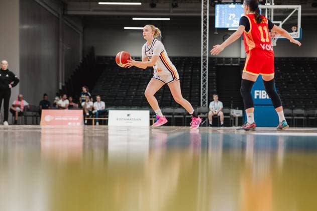 A German player controls the basketball and looks for a passing option, while a Montenegrin defender (No. 11) blocks her path. The scene takes place at the Kistamässan in Stockholm. A German player with the ball is under pressure from a Montenegrin defender. Copyright: xJoelxKruehlerx