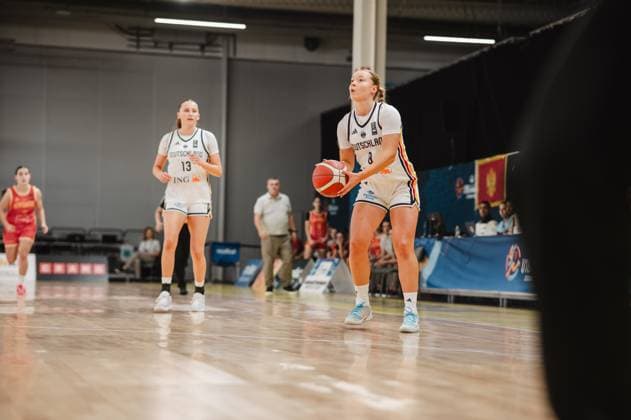 Darina Zraychenko 8 (Germany) is preparing to take a free throw, her eyes fixed on the basket and the basketball held in both hands. In the background stands Mia Wiegand 13 (Germany), while an opposing player from Montenegro can be seen on the left edge of the frame. Darina Zraychenko 8 of Germany taking a free throw in Stockholm Copyright: xJoelxKruehlerx