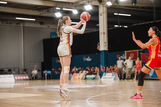 Frederike Askamp jumps and winds up for the shot, while a Montenegrin player defends with her hand raised. The scene takes place at the Kistamässan in Stockholm. Frederike Askamp, No. 14 for Germany, takes a jump shot against Montenegro. Copyright: xJoelxKruehlerx