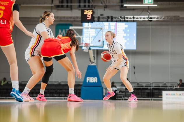 Noemi Schonauer (No. 6, Germany) dribbles the ball in the offensive zone while a teammate blocks an opponent from Montenegro. The game clock shows 3:56 in the 9th minute. Noemi Schonauer (No. 6, Germany) builds up the play against Montenegro. Copyright: xJoelxKruehlerx
