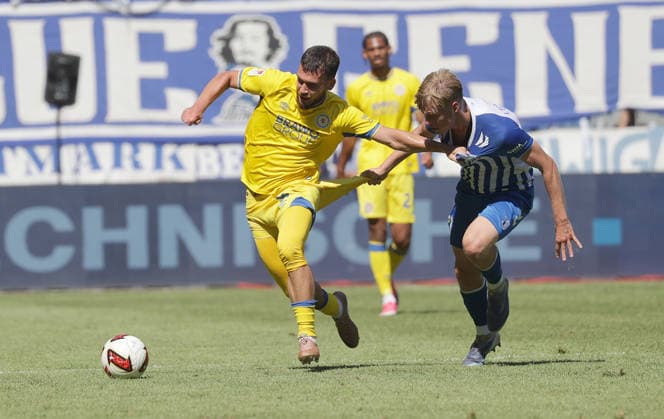 Head-to-head between Mehmet Aydin of Eintracht Braunschweig and Magdeburg’s Leon Mergner; Soccer, Men’s, 2026–2027 Season, 2. Bundesliga, Avnet Arena, Matchday 1, 1 FC Magdeburg vs. Eintracht Braunschweig, 1 6 DFL REGULATIONS PROHIBIT ANY USE OF PHOTOGRAPHS AS IMAGE SEQUENCES AND OR QUASI-VIDEO