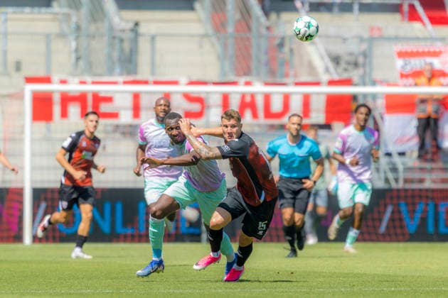 Ingolstadt, Germany, August 8, 2026, 3rd League 2026–2027, Matchday 1: FC Ingolstadt 04 vs. FC Würzburger Kickers. Pictured from left, in a tackle: Tarsis Bonga (FWK) and Jonas Scholz (FCI). DFB and DFL regulations prohibit any use of photographs as image sequences and or quasi-video. Audi Sportpark Bayern Copyright: xFotostandx xSchäferx