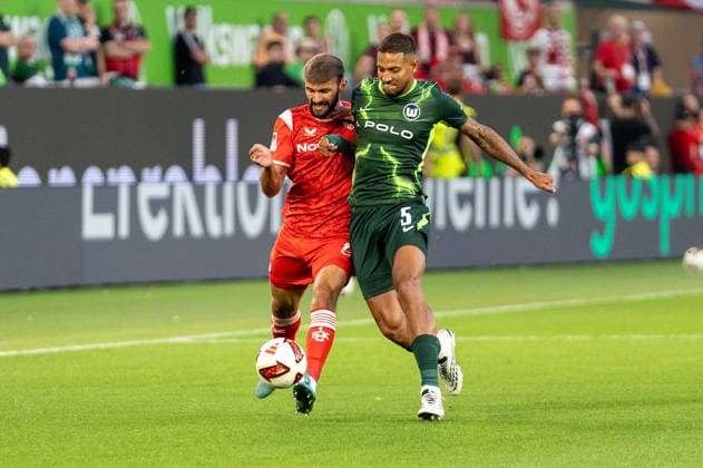 German Soccer 2. Bundesliga, Matchday 1, 2026–2027, VfL Wolfsburg vs. 1. FC Kaiserslautern on August 8, 2026, at the Volkswagen Arena in Wolfsburg: Simon Asta (1. FC Kaiserslautern) and Vinicius Souza (VfL Wolfsburg) in a tackle at the Volkswagen Arena in Wolfsburg, Germany Copyright: xSvenxHeidmannx