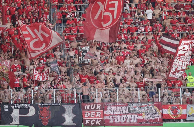 Fans from Kaiserslautern with their shirts off; Soccer, Men s, 2026–2027 Season, 2nd Division, Volkswagen Arena, VfL Wolfsburg vs. 1. FC Kaiserslautern DFL REGULATIONS PROHIBIT ANY USE OF PHOTOGRAPHS AS IMAGE SEQUENCES AND OR QUASI-VIDEO