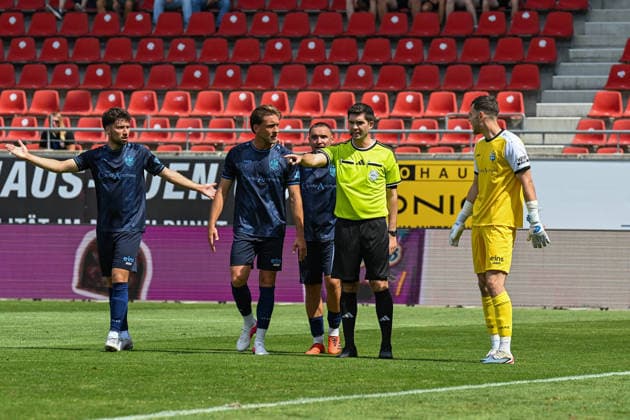 Soccer I Men s I 2026–2027 Season I Regionalliga I Matchday 4 I Hallescher FC vs. Chemnitzer FC I August 9, 2026 Referee Christoph Beblik (second from right) points to the penalty spot, Chemnitz players are standing around him at the Halle Saale Leuna Chemie Stadium in Saxony-Anhalt, Germany Copyright: xLobeca InesxHähnelx