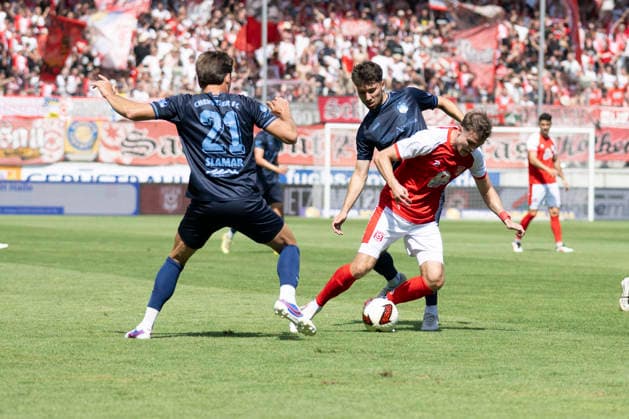 Regionalliga Northeast, Season 26–27: Hallescher FC vs. Chemnitzer FC, Halle, Germany, August 9, 2026. Pictured, from left: Dennis Slamar (Chemnitz), Tom Baumgart (Chemnitz), and Max Kulke (Halle). Halle-Saale-Leuna Chemie Stadium, Saxony-Anhalt, Germany
