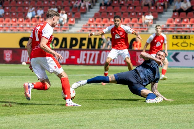 Regionalliga Northeast, Season 26–27: Hallescher FC vs. Chemnitzer FC, Halle, Germany, August 9, 2026. Pictured, from left, in a tackle: Fabrice Hartmann (Halle) and Jan Löhmannsröben (Chemnitz). Halle Saale Leuna Chemie Stadium, Saxony-Anhalt, Germany