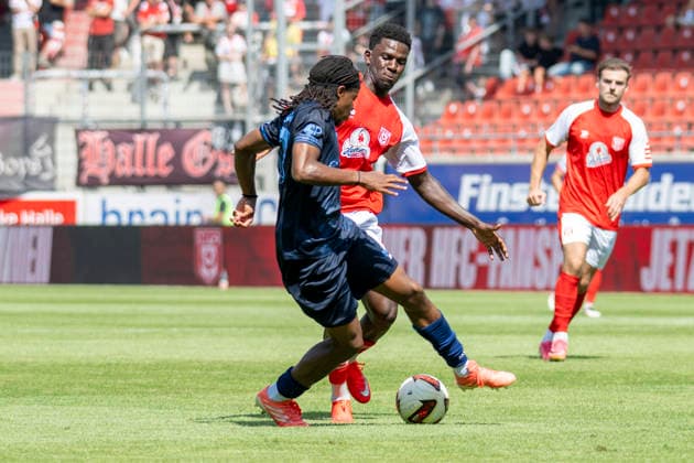 Regionalliga Northeast, Season 26–27: Hallescher FC vs. Chemnitzer FC, Halle, Germany, August 9, 2026. Pictured, from left, in a tackle: Ken Tchouangue (Chemnitz) and Bocar Baro (Halle). Halle-Saale, Leuna, Chemie Stadium, Saxony-Anhalt, Germany