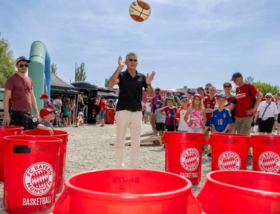 August 9, 2026, Google Pixel Women s Bundesliga Friendly Match: FC Bayern Women vs. Paris FC, at Sportpark Unterhaching; fan festival in front of the stadium; FC Bayern President Herbert Hainer throws a ball into the plastic bins at the basketball team s booth