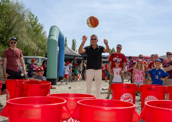 August 9, 2026, Google Pixel Women s Bundesliga Friendly Match: FC Bayern Women vs. Paris FC, at Sportpark Unterhaching; fan festival in front of the stadium; FC Bayern President Herbert Hainer throws a ball into the plastic bins at the basketball team s booth