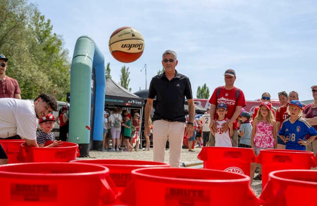 August 9, 2026, Google Pixel Women s Bundesliga Friendly Match: FC Bayern Women vs. Paris FC, at Sportpark Unterhaching; fan festival in front of the stadium; FC Bayern President Herbert Hainer throws a ball into the plastic bins at the basketball team s booth