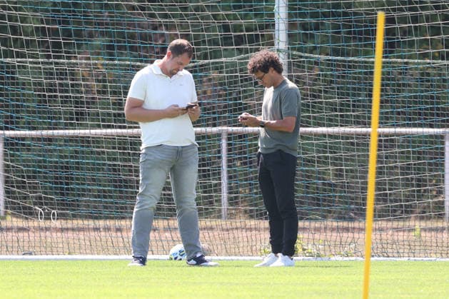 Training session for Sportfreunde Siegen: Managing Director Matthias Georg SI li and Sports Director Nico Michaty SI look at their smartphones. Regional League West soccer, training, Sportfreunde Siegen, on August 10, 2026, in Mudersbach, Germany