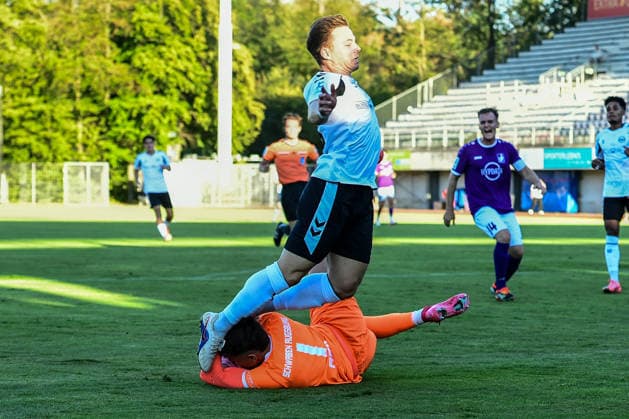 Bavarian Regional League: Wacker Burghausen vs. TSV Schwaben Augsburg, Burghausen, August 14, 2026. Maximilian Reil of TSV Schwaben Augsburg (No. 1) clears a dangerous situation in the penalty area against Jannis Turtschan of SV Wacker Burghausen, 23, Burghausen, August 14, 2026 Matchday 4 of the Bavarian Regional League: Wacker Burghausen vs. TSV Schwaben Augsburg, Burghausen, Flatbuy Stadium Copyright: xBEAUTIFULxSPORTS Märklx