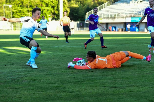 Bavarian Regional League: Wacker Burghausen vs. TSV Schwaben Augsburg, Burghausen, August 14, 2026. Maximilian Reil of TSV Schwaben Augsburg (No. 1) clears a dangerous situation against Jannis Turtschan of SV Wacker Burghausen, 23, Burghausen, August 14, 2026 Matchday 4 of the Bavarian Regional League: Wacker Burghausen vs. TSV Schwaben Augsburg, Burghausen, Flatbuy Stadium Copyright: xBEAUTIFULxSPORTS Märklx