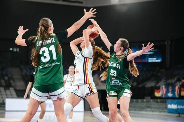 A player in the 2025 Prototype Cup Germany attempts a shot under heavy pressure from Kristale Saunoriute 31 Lithuania and Adrija Masiulionyte 99 Lithuania. The ball is contested from two sides at the Pitesti Arena. Kristale Saunoriute 31 Lithuania and Adrija Masiulionyte 99 Lithuania block the German attack Copyright: xJoelxKruehlerx