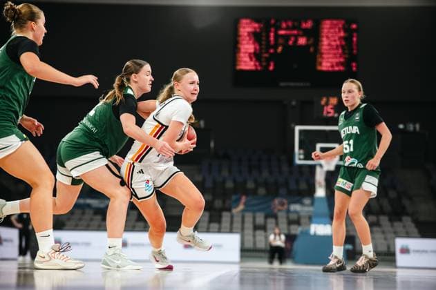 A player in the 2025 Prototype Cup Germany battles her way through two Lithuanian defenders with the ball. Kotryna Grunkyte (51, Lithuania) watches the action in the background. 2025 Prototype Cup Germany vs. Lithuania – Ball recovery at the Pitesti Arena Copyright: xJoelxKruehlerx