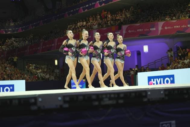 The Lithuanian group team takes the floor at the Festhalle Frankfurt with pink balls. All five gymnasts are wearing identical black-and-silver leotards with floral appliqués. Lithuania s group team with balls at the Rhythmic Gymnastics World Championships Copyright: xspeedshotx