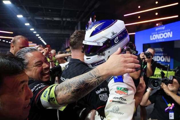 Mechanics embrace Pascal Wehrlein, driving the GER Porsche 94 and wearing a helmet, after his victory in the Parc Fermé, Race 1, FIA Formula E World Championship, Season 12, London E-Prix, August 15, 2026, Excel Exhibition Center