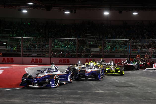 Pascal Wehrlein (GER) in Porsche 94 and Nico Mueller (SUI) in Porsche 51 lead Race 1 after Turn 1, FIA Formula E World Championship, Season 12, London E-Prix, August 15, 2026, Excel Exhibition Center