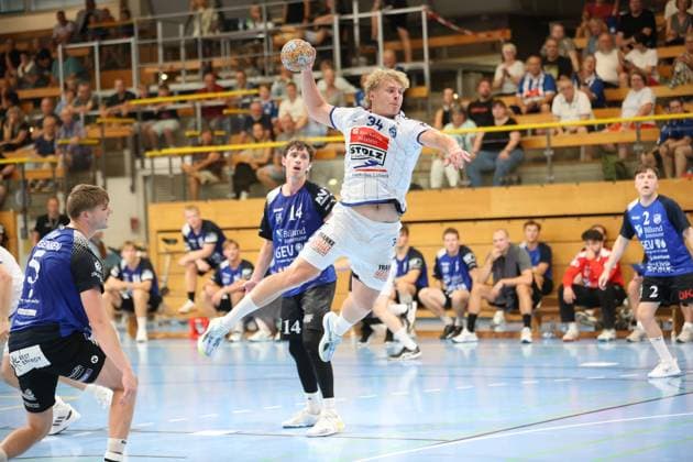 Thore Heinemann, No. 34 of VfL Lübeck Schwartau, jumps with the ball to take a shot, while Jon Katballe (No. 14, Grindstedt GIF) stands in front of him as a defender. The Hansehalle in Lübeck is packed with spectators. Thore Heinemann (No. 34, VfL Lübeck Schwartau) takes a jump shot at the Hansehalle. Copyright: xspeedshotx