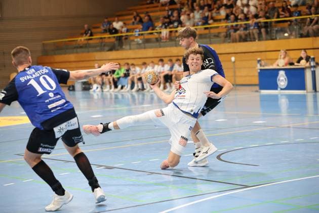 Magnus Holpert, 22, of VfL Lübeck Schwartau, fights his way through the Grindstedt GIF defense with the ball and is held back by an opponent; Nikolaj Svalastog, 10, of Grindstedt GIF, approaches from the left, while Holpert drops deep into his knees in a dynamic shot preparation. Magnus Holpert 22 of VfL Lübeck Schwartau in a one-on-one battle against Grindstedt GIF Copyright: xspeedshotx