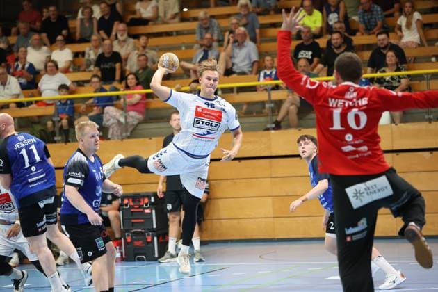 Einar Nickelsen, No. 42 of VfL Lübeck Schwartau, jumps high in the Hansehalle in Lübeck and goes up for a shot, while Lukas Sandgaard 2 of Grindstedt GIF and Jonas Nielsen 19 of Grindstedt GIF try to stop the attack. Christian Wetche 16 of Grindstedt GIF stretches out his arms in defense as Einar Nickelsen 42 of VfL Lübeck Schwartau attempts a jump shot against Grindstedt GIF. Copyright: xspeedshotx