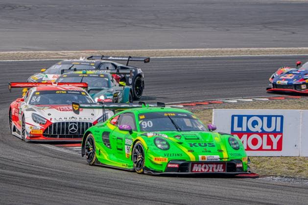Ricardo Feller’s neon-green Porsche 911 GT3 R 90 from Manthey Racing leads a tightly packed field of drivers through a turn at the Nürburgring. Behind him are, among others, the Mercedes-AMG GT3 84 driven by Tom Kalender of Mercedes-AMG Team Landgraf, as well as other DTM cars, including the Porsche 911 GT3 R 90 driven by Ricardo Feller of Manthey Racing leads the DTM field at the Nürburgring Copyright: xMichaelxSchäferx
