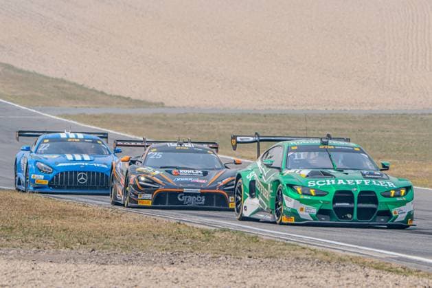Marco Wittmann in Schubert Motorsport’s BMW M4 GT3 No. 11 leads a group of three through a turn at the Nürburgring, closely followed by Ben Dörr’s McLaren 720S GT3 Evo No. 25, Dörr Motorsport, and the Mercedes-AMG GT3 No. 22 driven by Lucas Auer of Mercedes-AMG Team Landgraf. All three cars are running neck-and-neck in a thrilling battle for position. The BMW M4 GT3 No. 11 from Schubert Motorsport leads a three-way battle at the Nürburgring. Copyright: xMichaelxSchäferx