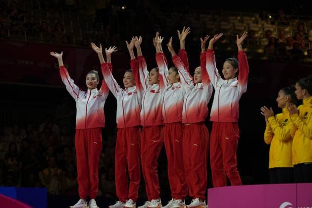 The Chinese team, dressed in red tracksuits, raises their arms in the air and celebrates against the backdrop of the packed Festhalle in Frankfurt. In the background, athletes in yellow jackets applaud. The Chinese team celebrates at the Rhythmic Gymnastics World Championships in Frankfurt. Copyright: xspeedshotx