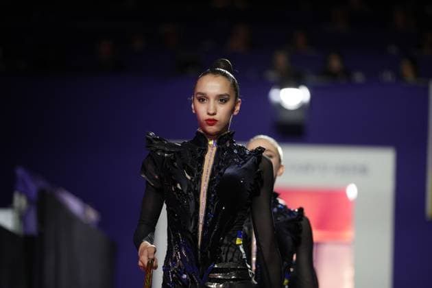 A gymnast from Ukraine in a black competition leotard enters the Festhalle Frankfurt during the opening parade for the 2026 World Rhythmic Gymnastics Championships. Another athlete can be seen in the background. A gymnast during the opening parade for the 2026 World Rhythmic Gymnastics Championships Copyright: xspeedshotx