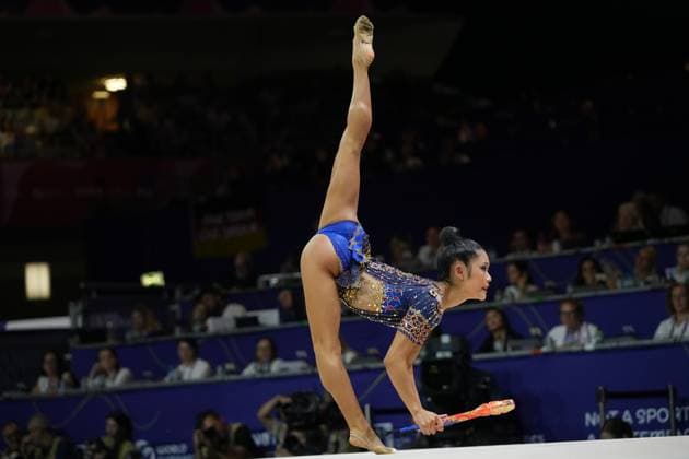 At the 2026 World Championships in Rhythmic Gymnastics at the Festhalle in Frankfurt, the gymnast from the U.S. performs a clubs routine featuring an extreme backbend and a vertically extended supporting leg. The blue, rhinestone-studded competition leotard and her precise body tension highlight the quality of the performance. U.S. gymnast performing a clubs routine with an extreme backbend at the World Championships in Frankfurt Copyright: xspeedshotx