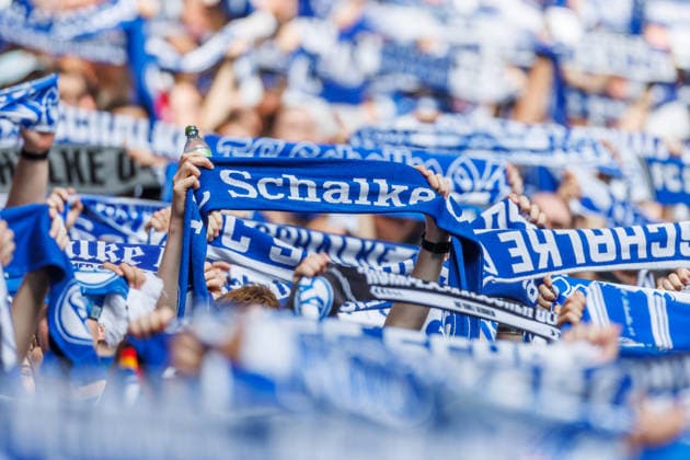Supporters of FC Schalke 04 wave their scarves during the preseason friendly match between FC Schalke 04 and Real Madrid at Veltins Arena on August 16, 2026, in Gelsenkirchen, Germany. Photo by Mario Hommes, DeFodi Images