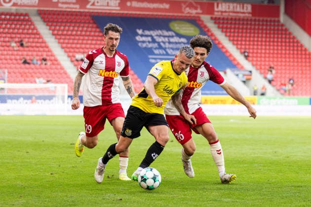 August 16, 2026, Soccer, GER, Season, 3rd Division, 2026–2027 Season, Matchday 2, SSV Jahn Regensburg 1 FC Saarbrücken: Florian Pick (Saarbrücken) in action against Adrian Fein (Regensburg) and Benedikt Bauer (SSV Jahn Regensburg). DFL regulations prohibit any use of photographs as image sequences and or quasi-video.