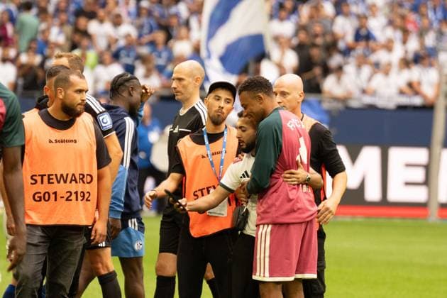 August 16, 2026: Soccer – FC Schalke 04 vs. Real Madrid, friendly match at the Veltins Arena in Gelsenkirchen. A Real Madrid fan runs onto the field after the kickoff to take a selfie with Kylian Mbappé of Real Madrid, 10 and is intercepted by security after the selfie and escorted off the field IMPORTANT NOTICE In accordance with the guidelines of the DFL and the DFB, it is prohibited to to use or allow the use of photographs taken in the stadium and or during the game in the form of sequential images and or video-like photo series Copyright: xJamesxZabelx