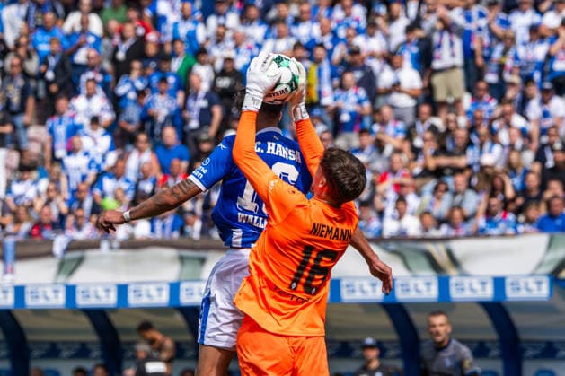 Rostock, Germany, August 16, 2026, 3. Liga 2026–2027, Matchday 2: FC Hansa Rostock vs. SV Waldhof Mannheim. Pictured, from left, in a tackle: Lukas Wallner of Hansa Rostock and goalkeeper Jan Niemann of Waldhof Mannheim. Copyright: xFotostandx xVoelkerx