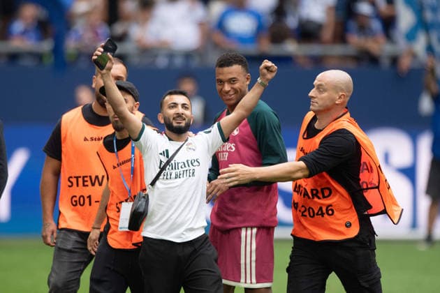 Security guards have caught a streaker and are holding him down; he’s cheering after being allowed to take a selfie with Kylian Mbappé of Real Madrid, Soccer friendly match: FC Schalke 04 vs. Real Madrid 0–3 on August 16, 2026, at the Veltins Arena in Gelsenkirchen, Germany. DFL regulations prohibit any use of photographs as image sequences and or quasi-video.