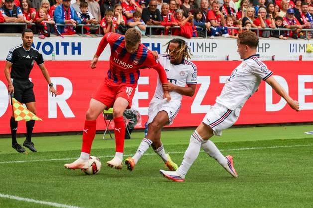 Julian Niehues (16), 1. FC Heidenheim 1846, goes head-to-head with Sascha Boey (23), FC Bayern Munich, and Tim Binder (47), FC Bayern Munich, 1 FC Heidenheim 1846 vs. FC Bayern Munich, Soccer, Men’s, Bundesliga, Friendly Match, 2026–2027 Season, August 18, 2026. DFB regulations prohibit any use of photographs as image sequences and or quasi-video. Heidenheim, Baden-Württemberg, Germany Copyright: xkolbert-press MartinxAgüerax