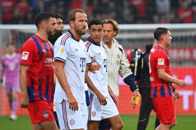 Jamal MUSIALA of Bayern Munich collapses again;faints, is led off the field by Dr. Peter UEBLACKER, FCB team doctor; featuring Harry KANE in a Bayern Munich soccer exhibition match: FC Heidenheim vs. FC Bayern Munich on August 18, 2025, at VOITH ARENA