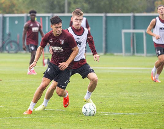 A battle for the ball between Fabian Rieder (FC Augsburg 32) and Anton Kade (FC Augsburg 30), white FC Augsburg, practice,