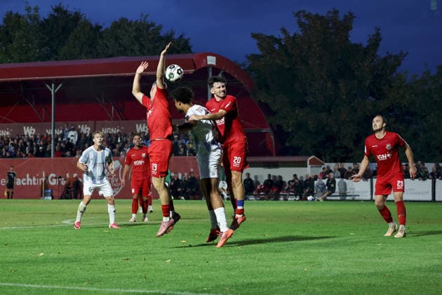August 18, 2026, Men s Soccer, 2026–2027 Season, Bavarian Regional League, Matchday 5: TSV Aubstadt vs. TSV 1860 Munich; Arian Ortivero Calderon 12, TSV 1860 Munich facing off against Jacob Engel (13), TSV Aubstadt, and Pascal Moll (20), TSV Aubstadt; Sulzfeld School Stadium, Aubstadt; NGN Arena, Bavaria, Germany